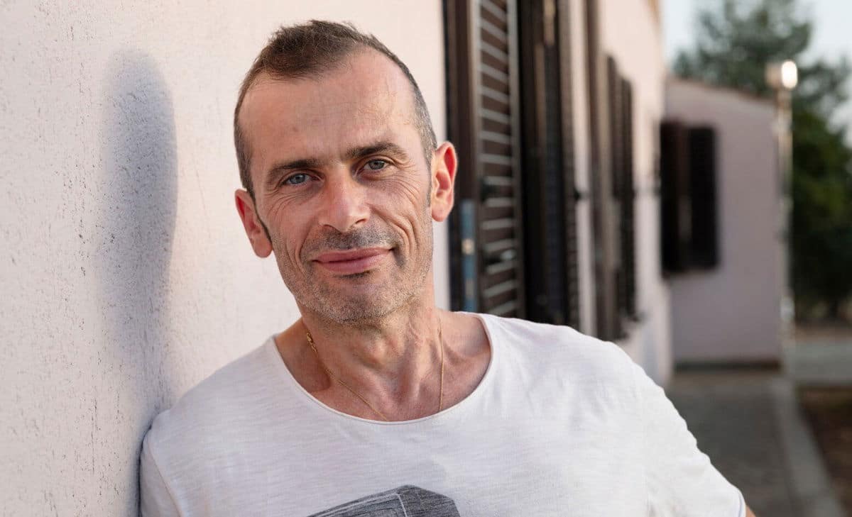 Photo portrait d'André devant sa maison. André vit avec la sclérose en plaques et aurait aimé en savoir un peu plus sur ce à quoi s'attendre en termes de problèmes vésicaux et intestinaux associés. 