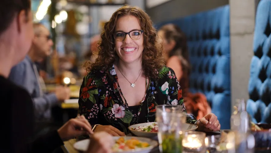 Photo de Marianne dînant dehors avec des amis. Marianne bénéficie d'un solide réseau d'amis qui l'aident. 