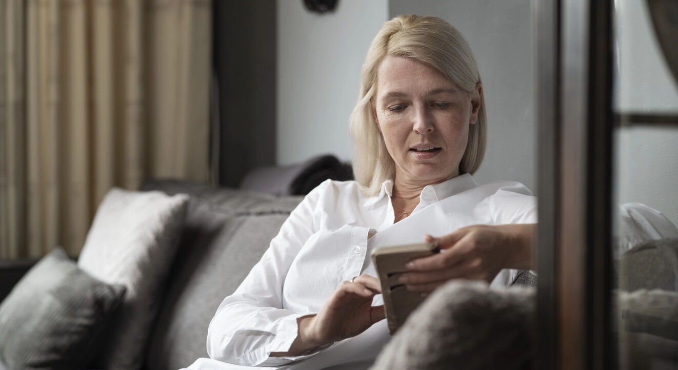 Image d'Ilse assise dans son salon. La sclérose en plaques endommage le système nerveux, perturbant les messages envoyés par le cerveau, et peut donc interférer avec un large éventail de fonctions corporelles. Votre vessie peut être particulièrement sensible à ces perturbations. 