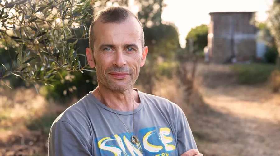 Photo portrait d'André debout à l'extérieur. André est atteint de sclérose en plaques et utilise l’irrigation transanale pour gérer ses problèmes de transit intestinaux.